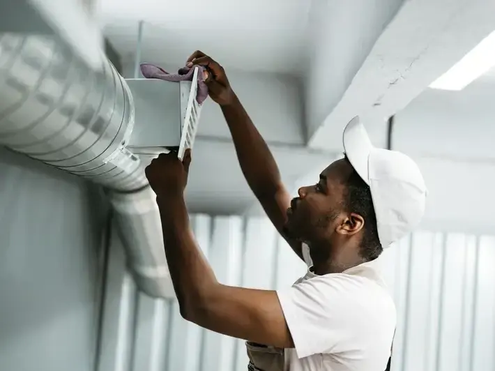 Technician performing air duct cleaning service in a Mahogany home near Mahogany Lake